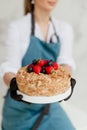 girl pastry chef holding honey cake with berries