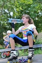 Girl pausing for a drink while roller skating Royalty Free Stock Photo