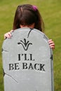 Girl peaking over headstone Royalty Free Stock Photo