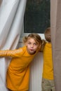 Girl peeping from behind curtains Royalty Free Stock Photo