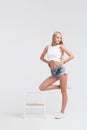 Girl with perfect body in denim shorts on white background Royalty Free Stock Photo