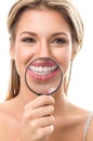 Girl with perfect teeth behind magnifying glass