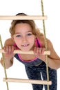 Girl performing gymnastic exercise on rope ladder. Royalty Free Stock Photo