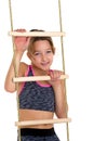 Girl performing gymnastic exercise on rope ladder. Royalty Free Stock Photo