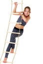 Girl performing gymnastic exercise on rope ladder. Royalty Free Stock Photo
