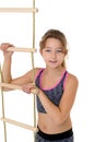 Girl performing gymnastic exercise on rope ladder. Royalty Free Stock Photo