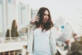 Girl on phone, papers with buildings on background