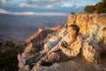 girl with a photo camera lying on the ground of the precipice of the great canyon in the golden hour