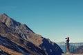 A girl photographer in a red cap with a camera stands on the balcony opposite snow Swiss Alps and forest of national park in Switz Royalty Free Stock Photo