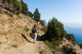 Girl photographer traveling alone. A young girl with a backpack is walking along a mountain path