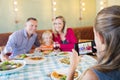 Girl photographing family through mobile phone Royalty Free Stock Photo