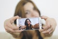 Girl photographing selfie herself with cell phone at home