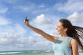 Girl photographing a selfie with a smart phone on the beach