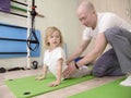 girl on physiotherapy in a children therapy center. Kid doing exercises training with physiotherapists