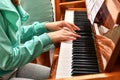 A girl on the piano learns new pieces from notes and plays at a music school Royalty Free Stock Photo