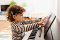 Girl piano student places a sheet of music on her piano to practice