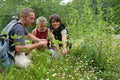 Girl picking flowers with parents Royalty Free Stock Photo