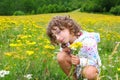 Girl picking flowers in yellow spring meadow