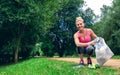 Girl picking up trash doing plogging Royalty Free Stock Photo