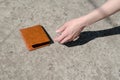 Girl picks up a brown wallet. Found a wallet on the road. Royalty Free Stock Photo