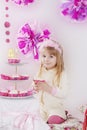 Girl with piece of cake at pink decoration birthday party