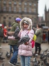Girl with pigeons on the Dam in Amsterdam