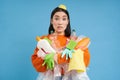 Girl with piles of garbage, surrounded by litter, looks concerned, sorts waste and recycles, blue background