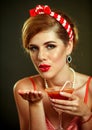 Girl in pin-up style drink martini cocktail and blow kiss .