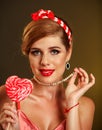 Girl in pin-up style lick striped lollipops.