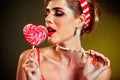 Girl in pin-up style lick striped lollipops.