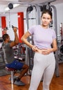 Girl pinching skin of her belly at gym