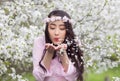 Girl in Pink Ao Dai blowing white cherry petals from her palms