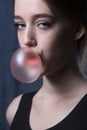 Girl with pink bubble of chewing gum