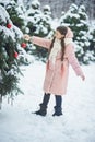 Girl in pink coat in snow Park. Girl plays in winter Park. Adorable child walking in snow winter forest Royalty Free Stock Photo
