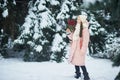 Girl in pink coat in snow Park. Girl plays in winter Park. Adorable child walking in snow winter forest Royalty Free Stock Photo