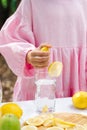 a girl in a pink dress makes lemonade from a fresh lemon Royalty Free Stock Photo