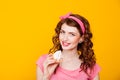 Girl in pink dress pinup-style eats cake with cream Royalty Free Stock Photo