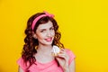 Girl in pink dress pinup-style eats cake with cream Royalty Free Stock Photo