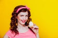 Girl in pink dress pinup-style eats cake with cream Royalty Free Stock Photo