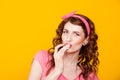 Girl in pink dress pinup-style eats cream licks fingers Royalty Free Stock Photo