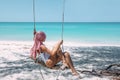 Girl with pink hair hanging on swing at beach Royalty Free Stock Photo