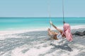 Girl with pink hair hanging on swing at beach Royalty Free Stock Photo