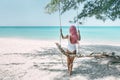 Girl with pink hair hanging on swing at beach Royalty Free Stock Photo