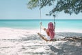 Girl with pink hair hanging on swing at beach Royalty Free Stock Photo