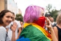 Girl with pink hair and an LGBT flag at a rally