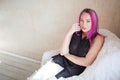 Girl with pink hair sits in a Chair in a white room Royalty Free Stock Photo