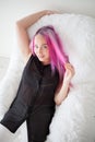 Girl with pink hair sits in a Chair in a white room Royalty Free Stock Photo