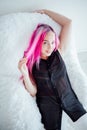 Girl with pink hair sits in a Chair in a white room Royalty Free Stock Photo