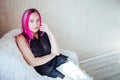 Girl with pink hair sits in a Chair in a white room Royalty Free Stock Photo