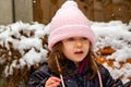 A girl in a pink knit hat playing in the snow Royalty Free Stock Photo